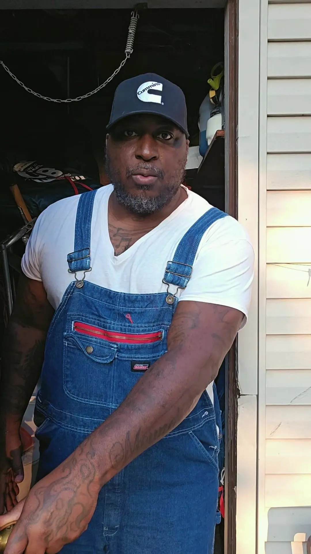 Carlos Kane at the shed door, in his overalls