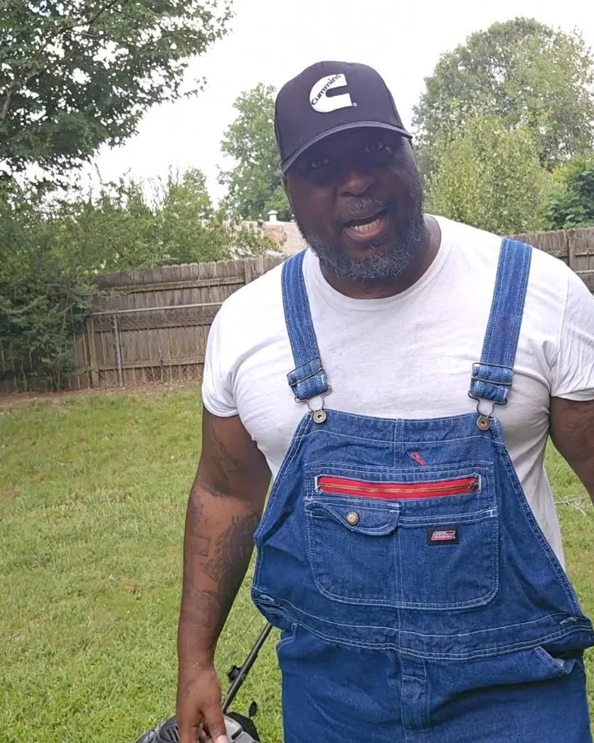 Carlos Kane in the yard, in overalls